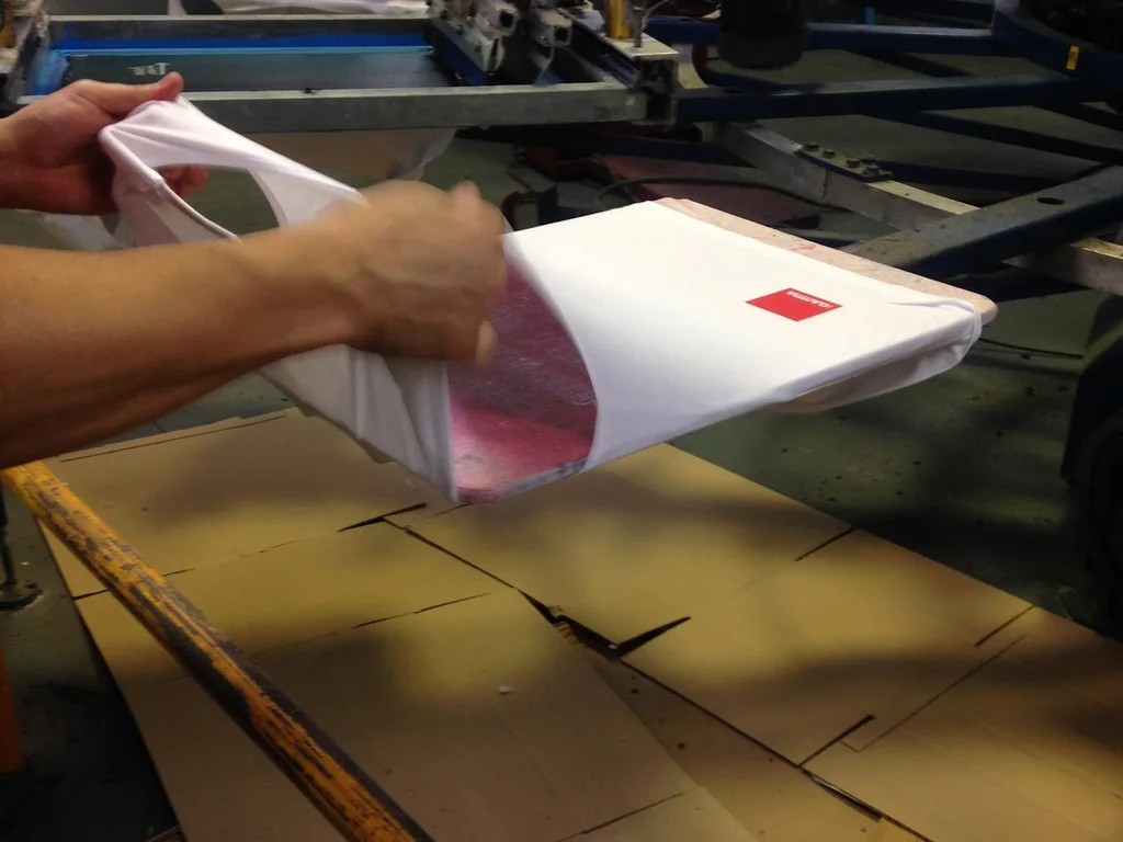 Camiseta serigrafiada saliendo de la máquina